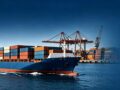 Horizontal banner background of container cargo ship at busy seaport, for US cross‑border ocean freight logistics content