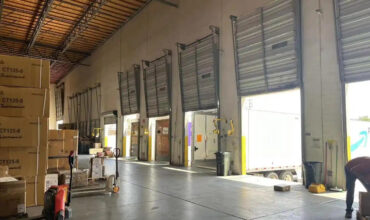 Interior view of US east overseas warehouse loading bays, stacked cartons and loading truck for cross-border order fulfillment
