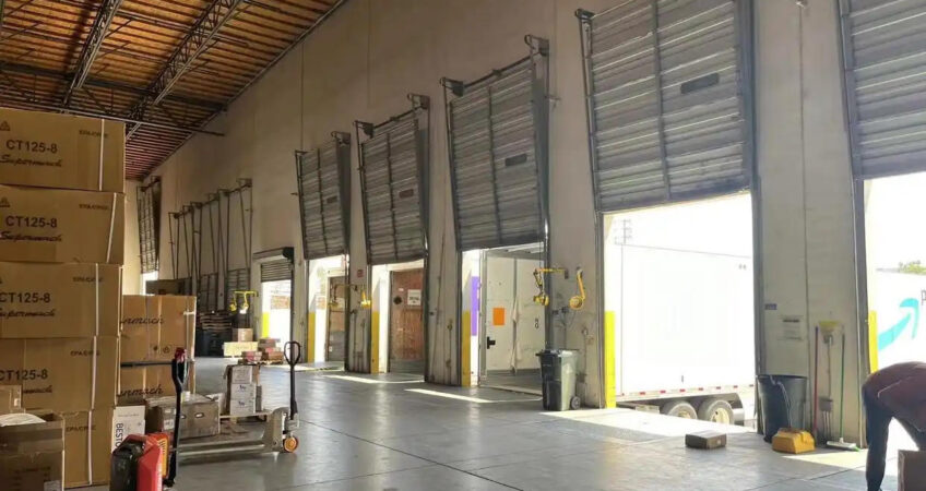 Interior view of US east overseas warehouse loading bays, stacked cartons and loading truck for cross-border order fulfillment